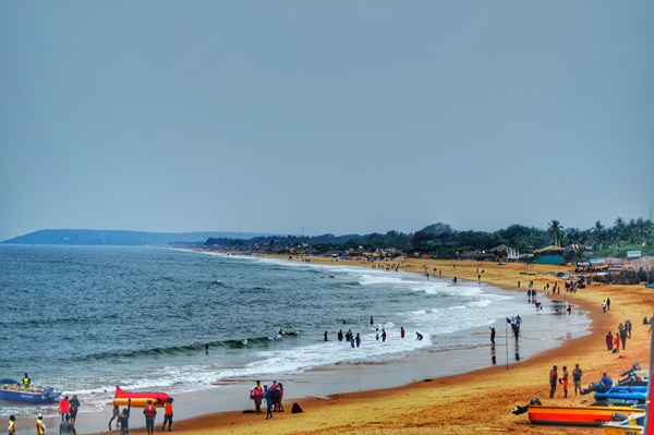 A group enjoying a sunset at a lively beach in North Goa