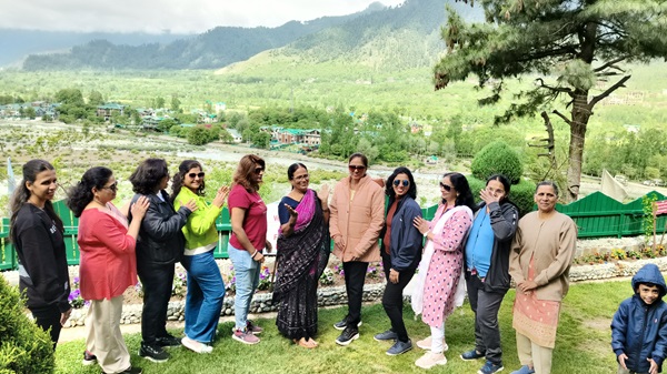 A group posing in front of a scenic Kashmir backdrop